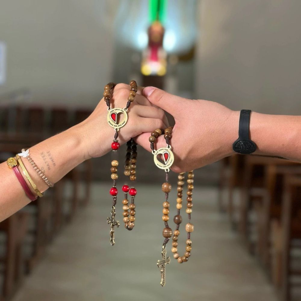 Dois terços nas mãos do casal diante do altar